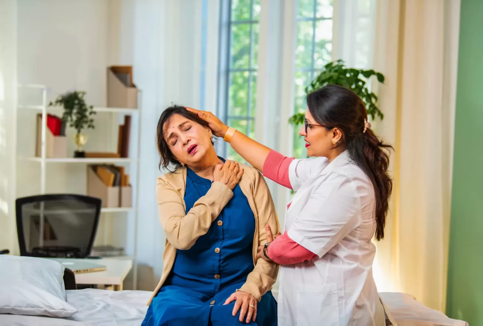 Indian physiotherapist assessing shoulder and back pain in naturopathy clinic